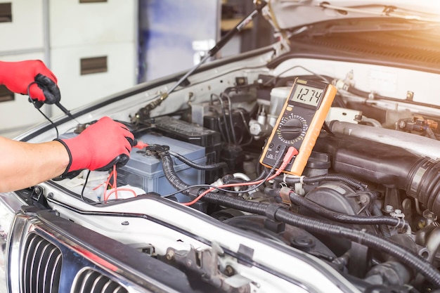 Mecánico de automóviles revisando el sistema eléctrico del automóvil