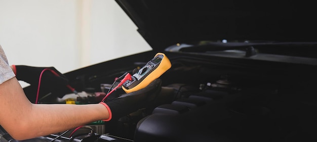 Foto mecánico de automóviles revise las baterías, repare y reemplace las piezas del motor.