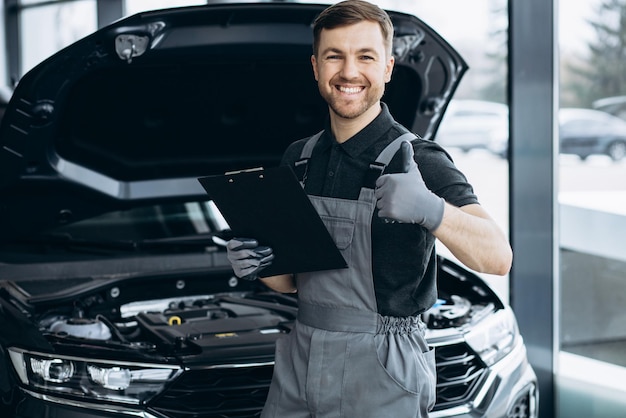 Foto mecánico de automóviles en el servicio de automóviles revisando el automóvil