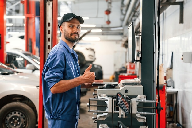 Mecánico de automóviles trabajando en el garaje Servicio de reparación