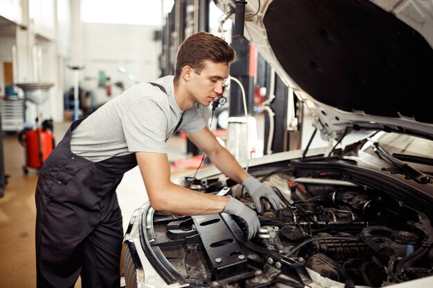 Un mecánico calificado está buscando errores en un servicio de reparación de automóviles.