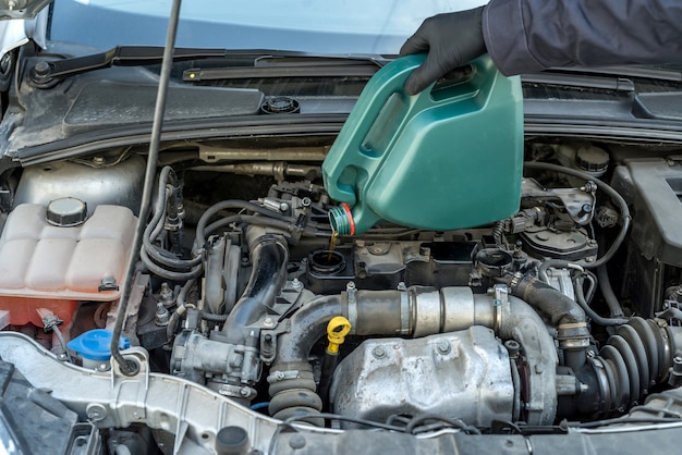 El mecánico cambia el aceite del motor, repara el automóvil. reparación de vichile