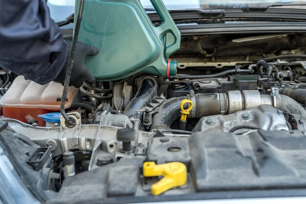 El mecánico cambia el aceite del motor, repara el automóvil. reparación de vichile