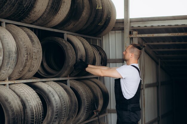 Mecánico cambiando neumáticos en un servicio de automóviles