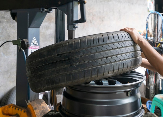El mecánico del coche está reparando el neumático.