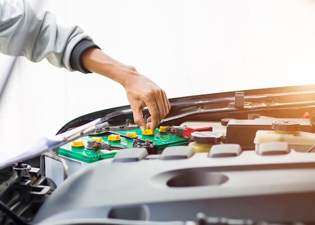 El mecánico comprueba el estado de la batería del coche.