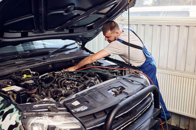 El mecánico conecta el sistema de aire acondicionado en el servicio automático