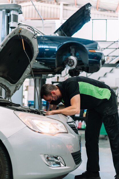 mecânico consertando carro em oficina mecânica