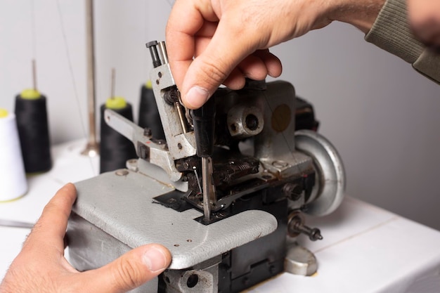 Mecánico cualificado reparando máquinas de coser industriales en fábrica.