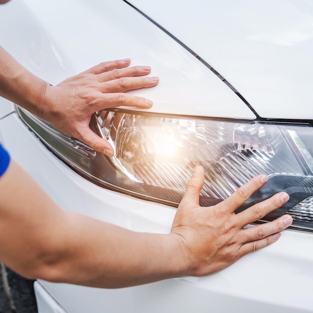 Mecânico de automóveis asiáticos, verificando o farol na garagem de serviço de automóveis Engenheiro de manutenção mecânica trabalhando na indústria automotiva Conceito de manutenção e reparo de automóveis