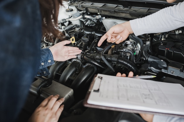 Mecânico de automóveis confiável, falando com um cliente do sexo feminino