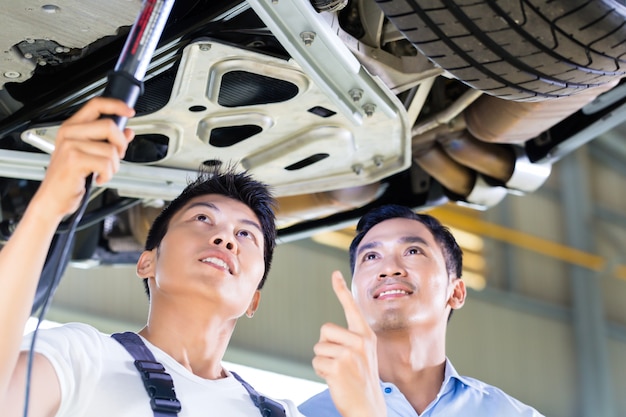 Mecânico de automóveis e cliente na oficina de automóveis asiáticos