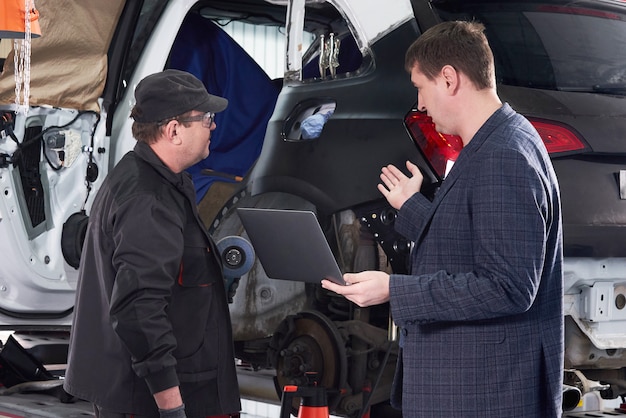 Mecânico de automóveis e técnico trabalhando na oficina