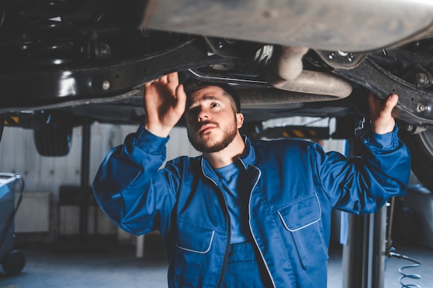 Foto mecânico de automóveis, reparando carros na garagem de serviço