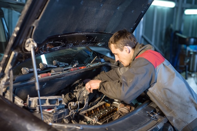 Mecânico de automóveis, trabalhando na garagem. Serviço de reparo.