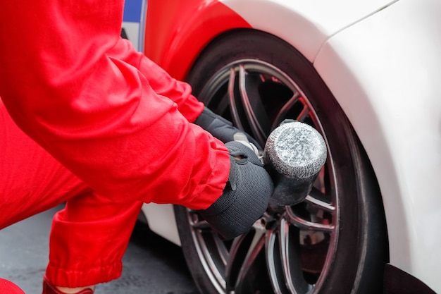 Foto mecânico de automóveis trocando a roda do carro