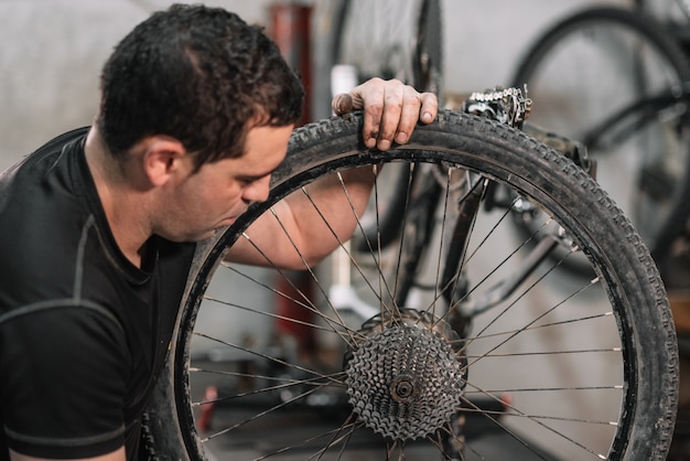 Mecânico de bicicletas em uma oficina no processo de reparo.