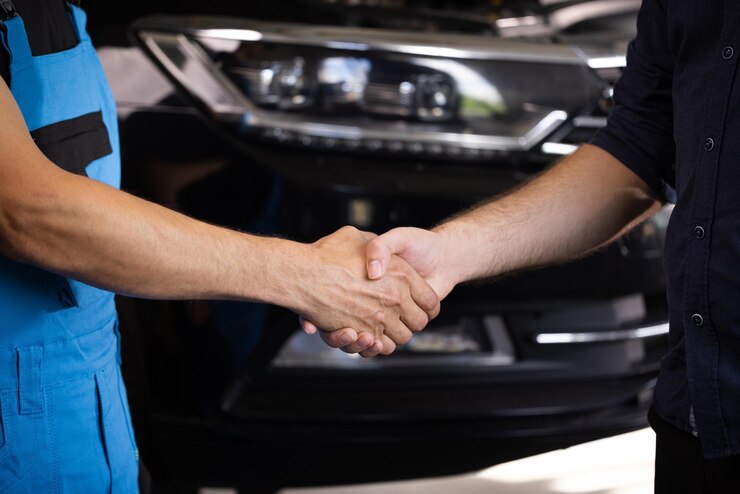 Foto mecânico e cliente apertando as mãos em uma oficina de reparos automotivos dois homens irreconhecíveis auto