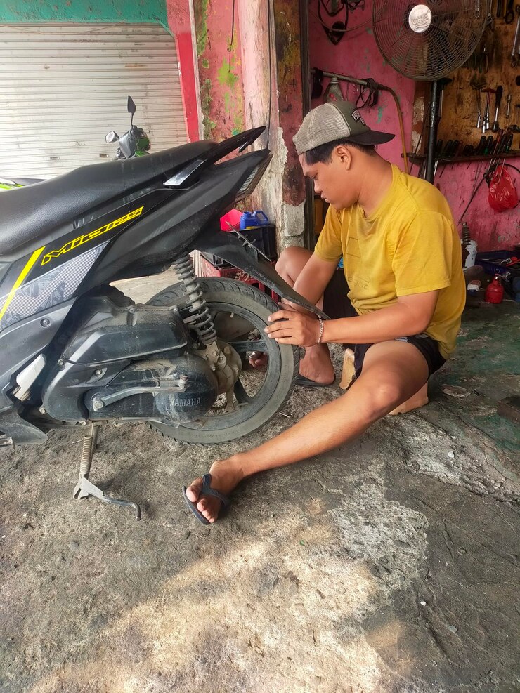 un mecánico está reparando un neumático de motocicleta en un taller