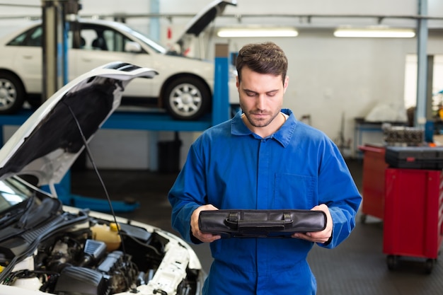 Mecánico examinando bajo el capó del coche