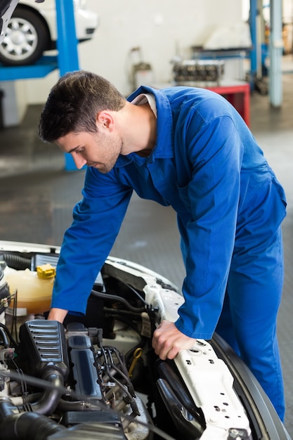 Mecánico examinando bajo el capó del coche