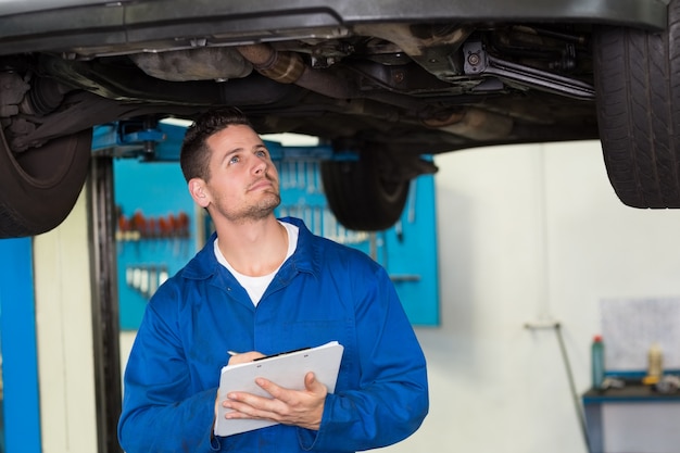 Mecánico examinando debajo del coche