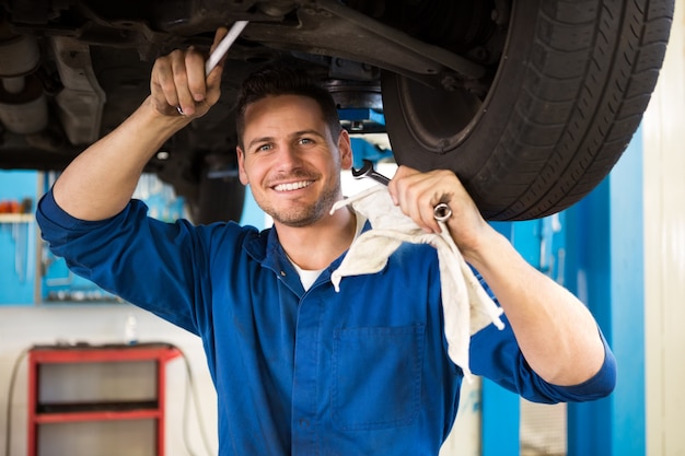 Mecánico examinando debajo del coche