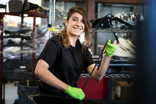 Mecánico femenino sacando el sello de clima de un vehículo