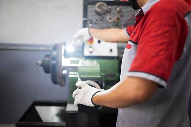 Un mecánico de frenos usa un torno para automatizar los discos de freno del automóvil reconstruir la superficie del disco de freno en el torno