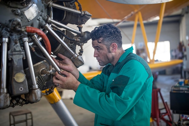 Mecánico en hangar reparando avionetas