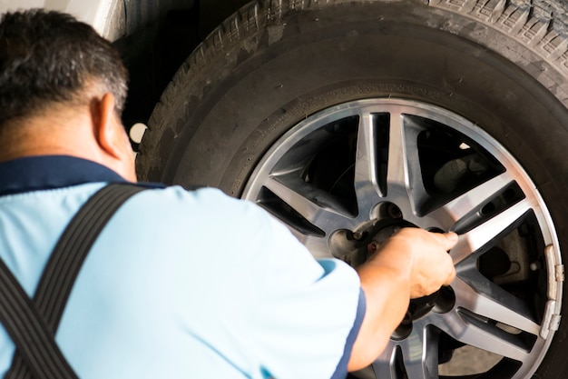 Mecánico Holding Car Tire en el garaje