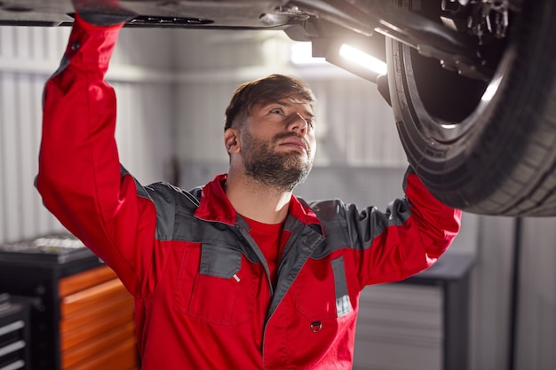 Foto mecánico inspeccionando el chasis del vehículo roto.