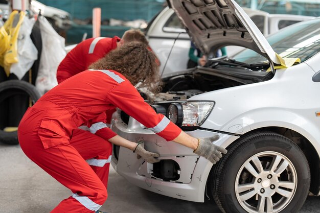 Foto mecánico instalando la falda delantera en el servicio de garaje de automóviles