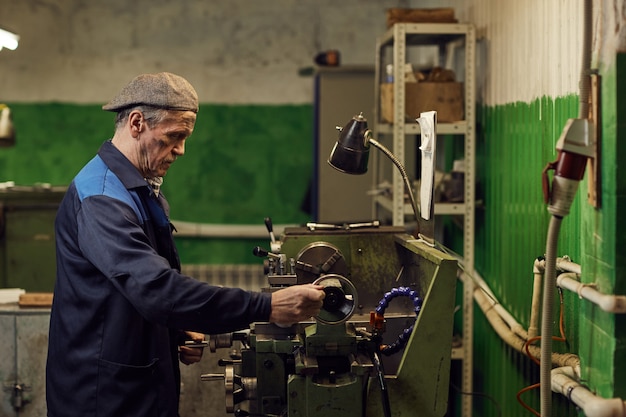 Mecánico maduro trabajando en torno