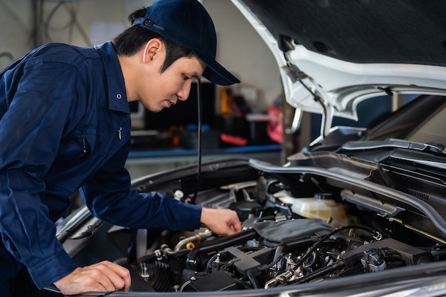 Mecánico masculino control y reparación de motores, servicio de automóviles