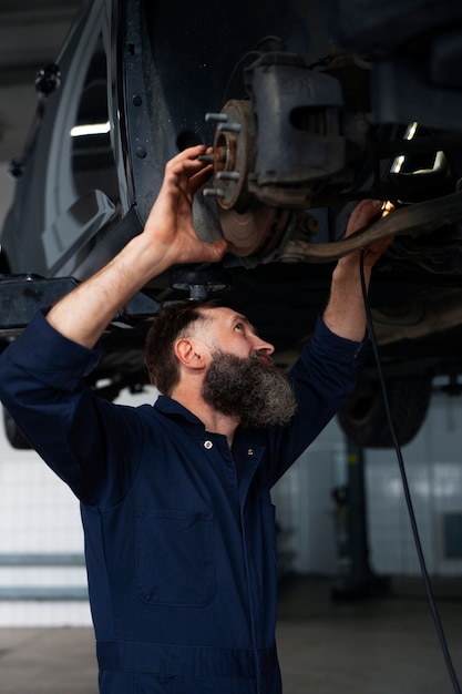 Mecânico masculino trabalhando no carro na oficina mecânica