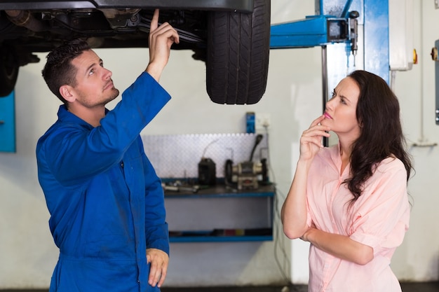 Mecânico mostrando o problema do cliente com o carro