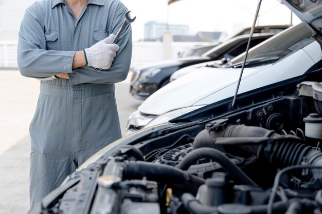 Mecánico de motores mano de mecánico de automóviles con llave inglesa garaje de reparación de automóviles