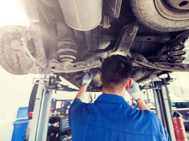 Foto mecánico o herrero reparando coches en el taller