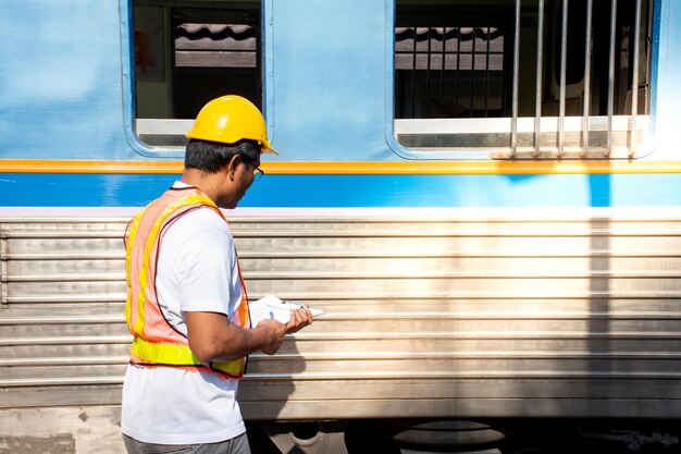 Foto mecánico de pie junto al tren