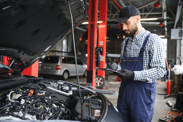 Mecánico profesional está trabajando en un automóvil en un servicio de automóviles