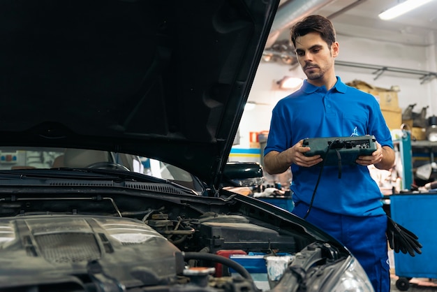 Mecánico profesional que repara el motor del coche en el garaje.