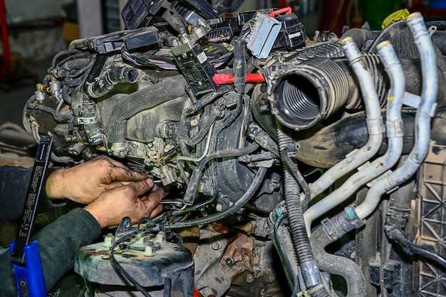 Mecánico que repara un motor de coche en el taller