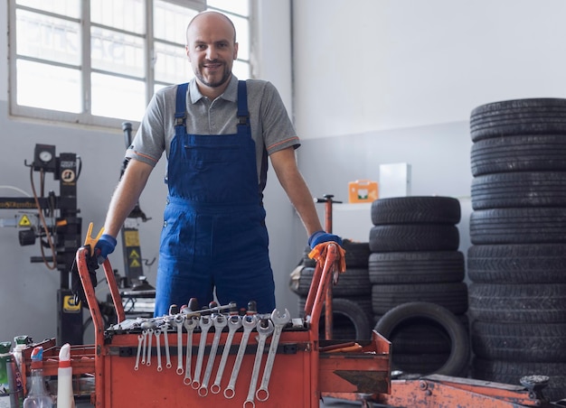 Foto mecânico que trabalha na oficina de reparação automóvel