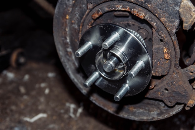 mecánico quita el cubo de la rueda del coche