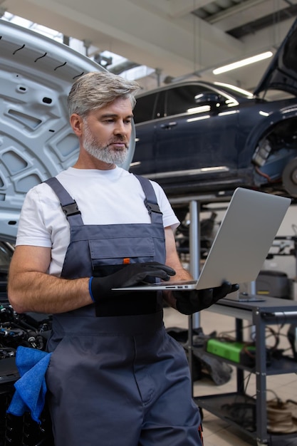 Mecánico realizando diagnósticos con una computadora portátil