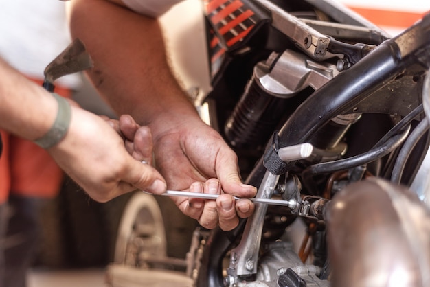 Foto mecánico reparación de un motor de motocicleta en un taller.