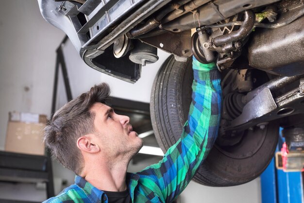 Foto mecânico reparando carro em uma oficina de reparação de automóveis