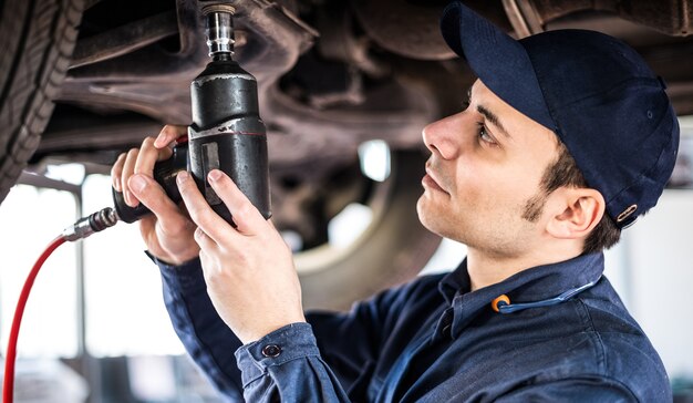 Mecánico reparando un carro levantado