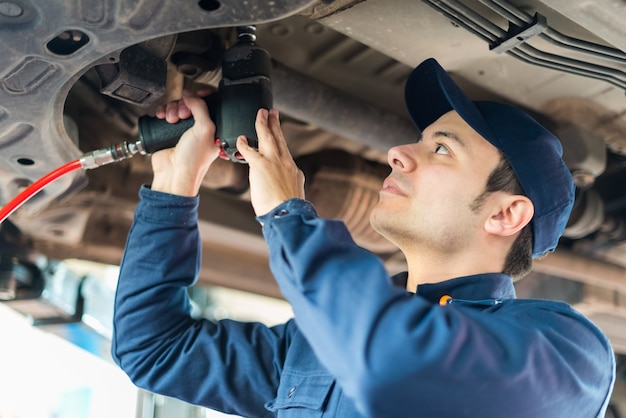 Mecánico reparando un carro levantado